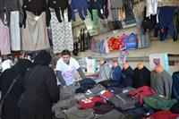 “Kanserde Erken Teşhis Hayat Kurtarır” sloganı baskılı tişörtler giyen pazar esnafı satış yaparken.