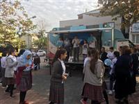 Sağlıklı Yaşam aracından Şehit Deniz Piyade Er Tahsin Şen Ortaokulu öğrencilerine broşür dağıtılıyor.