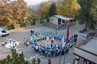 Öğrenciler okul bahçesinde el ele tutuşarak diyabetin sembolü olan mavi halka şekli yapıyor.